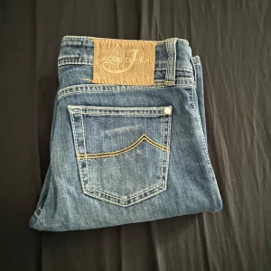 Jacob Cohen  jeans, storlek 27 - Snygga blå jeans från Jacob Cohen i klassisk modell med raka ben och kontrastsömmar. Jeansen har fem fickor, diskret logga på myntfickan och patch i mocka bak. Tillverkade i Italien av mjukt bomullsdenim. Perfekta för dig som gillar premiumjeans med stilren look.