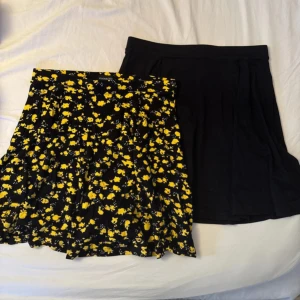 Två korta kjolar, en blommig och en svart - Säljer två snygga kortkjolar! Ena är svart med enkel design, andra är svart med gula blommor och volang. Perfekta för sommar eller vår och lätta att matcha med sneakers eller boots.