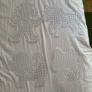 Stora pärlplattor – figurer och djur - Fyra stora pärlplattor i genomskinlig plast, formade som olika djur och figurer. Perfekt för kreativa projekt med pärlor – skapa egna mönster och motiv! Passar både nybörjare och dig som vill ta ditt pyssel till nästa nivå.