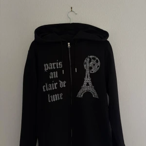 Svart Zip-hoodie från Blinglucid. - Svart Zip-hoodie från Blinglucid. Mycket bra skick. Rhinestone.