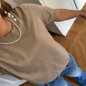 Beige tröja  - Säljer en jätte fin tröja från Lindex. Den är beige o har korta ärmar. Men den har en liten defekt på ryggen.