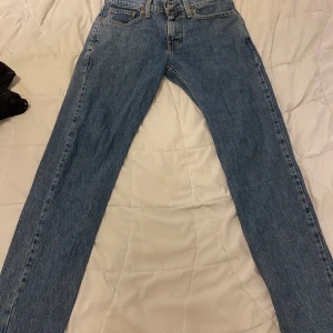 Levi's 502 blå jeans highball - Säljer ett par klassiska Levi's 502 highball jeans i blå denim. De har raka ben, fem fickor och snygga kontrastsömmar. Ikonisk läderpatch bak och röd Levi's-tagg på bakfickan. Perfekta för dig som gillar en tidlös och avslappnad look.