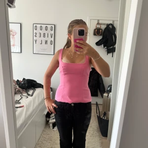Rosa linnetopp med rosett -  Supersöt rosa linnetopp från zara med breda axelband, fyrkantig urringning och en stor rosett i ryggen. Toppen har figurnära passform och är tillverkad i ett slätt, lätt stretchigt material. Perfekt för dig som vill sticka ut med en färgglad och trendig look.