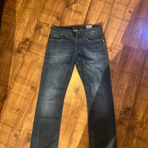 G-Star Raw 3301 Jeans - Säljer ett par klassiska G-Star Raw 3301 jeans i mörkblå tvätt. Jeansen har raka ben, fem fickor och snygga kontrastsömmar. Perfekta för dig som gillar en tidlös och clean look. Materialet är slitstarkt denim i bomull. Riktigt bra kvalitet med snygga slitningar.