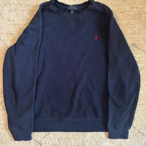 Ralph Lauren tröja - Säljer en mörkblå tröja från Ralph lauren i storleken XL, men passar mig perfekt som använder M. Den är i bra skick och jag säljer den för endast 299 priset går att diskuteras. Om du har några frågor alls skriv!!