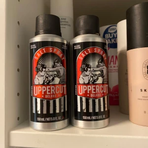 Uppercut Deluxe Salt Spray 150ml - Salt spray från Uppercut Deluxe i en cool silverfärgad metallflaska med svart och röd etikett. Ger håret textur och volym med en fräsch känsla. Perfekt för att skapa strandiga, rufsiga frisyrer. Innehåller 150 ml.