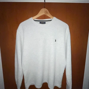 Grå Ralph Lauren sweatshirt- Stilren & Bekväm - Mjuk och varm sweatshirt från Ralph lauren i klassiskt grått. Ikoniska Polo - loggan broderad på bröstet.  Perfekt för både avslappnade dagar och en snygg vardags look. Tidlös design som aldrig går ur mode, i fint skick och redo för en ny ägare. Diskutera med ägare innan köp!