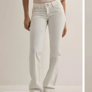 Vita bootcut jeans  - Vita jeans med bootcut-modell och låg midja, Aldrig använda, endast testade. Dem är i nytt skick utan prislappen kvar. Priset kan förhandlas