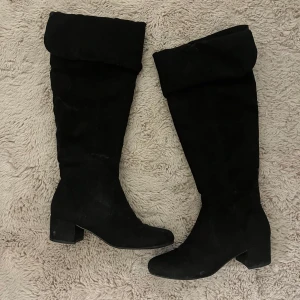 Svarta stövlar med dragkedja - Snygga svarta stövlar i mocka med dragkedja på insidan och en bred klack. Perfekta för en stilren look.