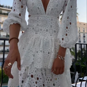 Vit spetsklänning med volanger - Säljer en superfin vit klänning i spets med volanger och v-ringning. Stoleken är 42 men är insydd så skulle säga att den passa någon som har stolek 40! Klänningen är även bara använd vid ett tillfälle. Perfekt för sommaren/student eller skolavslutning! 