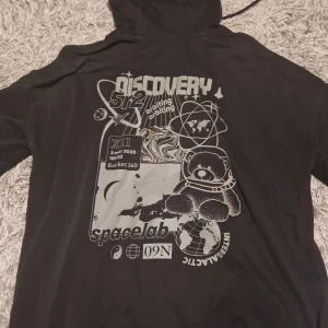 Svart NASA hoodie - Säljer en svart hoodie med NASA-tryck. Tröjan har en stor ficka framtill och en cool rymdinspirerad design på baksidan. Perfekt för dig som gillar rymden och vill ha en bekväm och stilren tröja. Den ganska sliten i ärmslutet men inget som man tänker på😽