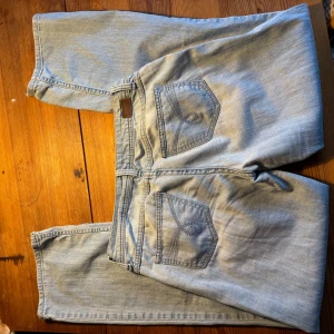 Ljusblå jeansbyxor - Säljer ett par ljusblå jeansbyxor från SPF. De har en klassisk femficksdesign med knapp och dragkedja framtill. Perfekta för en avslappnad stil.
