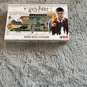 Harry Potter Magical Beasts Board Game - Säljer ett Harry Potter Magical Beasts brädspel. Spelet har en spännande design med bilder från Harry Potter-världen och inkluderar olika kort och spelplaner. Perfekt för fans av serien som vill uppleva magiska äventyr hemma. Köp direkt eller ge prisförslag! 🧙‍♂️