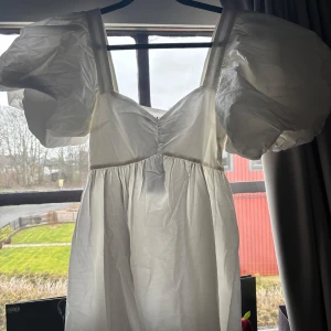 Puffig klänning från showpo - Säljer en söt vit klänning från Showpo med puffiga ärmar och en smickrande passform. Perfekt för studenten eller sommaren. Klänningen har en lätt och luftig design. Den är helt ny med lappen kvar💕