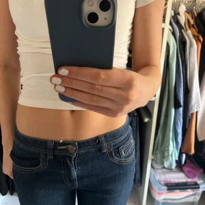 Mörkblå jeans med broderade bakfickor - Snygga mörkblå jeans med broderade detaljer på bakfickorna. De är perfekt lågmidjade och sitter jätte bra. Kolla gärna in mina andra annonser💖Midjemåttet är ca 36cm och innerbens längden ca 70cm