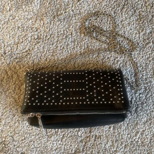 Svart axelväska med nitar - Väska köpt på Zalando som inte kommer till användning då jag använder guld smycken. 💓