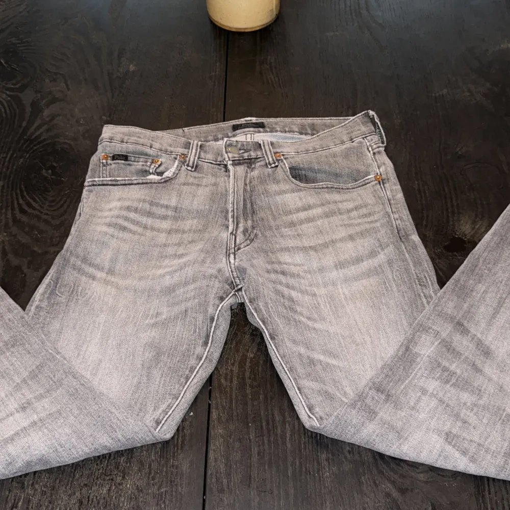 Snygga grå jeans från Polo med en klassisk femficksdesign. De har en knappgylf och bälteshällor, vilket gör dem perfekta för en avslappnad stil. Jeansen har en lätt tvättad look som ger dem en trendig touch.. Farkut & Housut.