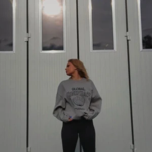 Grå sweatshirt med tryck - Säljer en grå sweatshirt med tryck från ett gammalt samarbete. Litet hål på framsidan som syns på andra bilden. Ska flytta snart så vill gärna bli av med allt så fort som möjligt (pris kan diskuteras)💕