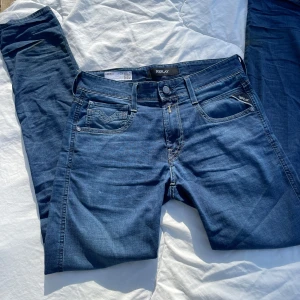 Replay anbass - Snygga blå jeans från Replay i modellen Anbass. De har en klassisk femficksdesign med dragkedja och knapp framtill. Dom är i storlek 29W 32L skriv. Lapparna följer självklart med om man vill ha de. Byxorna köptes u vintras men har tröttnat lite på dom så vill att dom ska gå vidare. Skriv till mig vid frågor eller om mer bilder💛