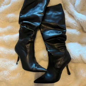 Svarta stövlar med klack - Snygga svarta stövlar i skinn med spetsig tå och hög klack. De har en dragkedja på sidan för enkel på- och avtagning. Perfekta för en stilren look. använda nån enstaka gång så dom är som nya😍😍