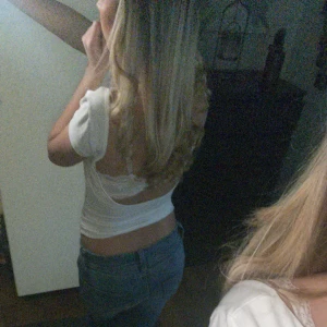 Vit kortärmad topp - Säljer en stilren vit kortärmad topp med tight passform. Perfekt för en enkel och snygg look. Öppen rygg💞