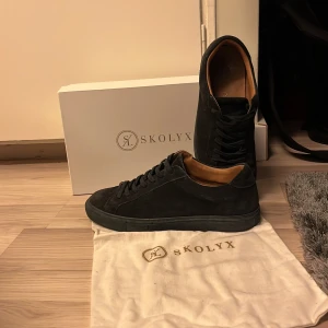 Stilrena mocka skor - Säljer mörkblå sneakers från Skolyx i skicket 8.5/10. Skorna har inga defekter och kommer att rengöras innan de fraktas, dustbag och box följer med! Passar perfekt för dig som vill ha ett par fräscha skor för en billig peng. Skorna är inspirerade av loubs och är som sagt ett billigare alternativ till sommaren. Hör av er kring frågor/bud 🤝
