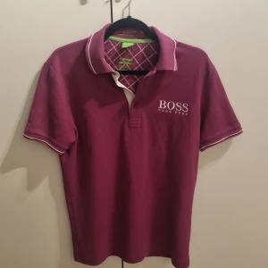 Pikétröja från Hugo Boss - Pikétröja från Hugo Boss med vit logga på bröstet och ryggen.