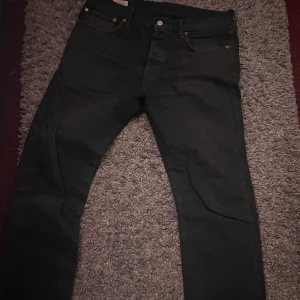 Svarta Levis 501 jeans - Snygga svarta Levis 501 jeans med klassisk design. De har en knappgylf och femficksmodell. Perfekta för en stilren look.