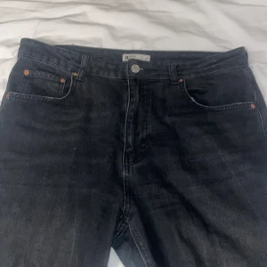 Svarta jeans med fransade kanter - Snygga svarta jeans med en cool fransad kant vid bensluten. De har en klassisk femficksdesign och en knappgylf. Perfekta för en avslappnad stil med en twist. High waist