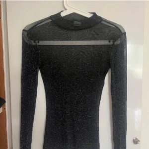 Svart glittrig topp från Gina Tricot - Svart glittrig festtröja från gina tricot i storlek xs, genomskinlig och stretchig☺️☺️