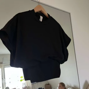 Svart ribbad tröja från Missguided - Säljer en svart ribbad tröja från Missguided. Tröjan har en rund halsringning och är croppad i modellen, vilket ger en trendig look. Perfekt att styla med höga jeans eller kjol.