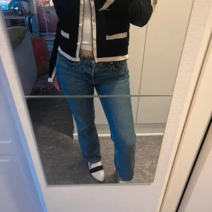 Blå raka jeans från Weekday - Säljer ett par klassiska blå jeans från Weekday i modellen 'Pin Mid Straight'. Jeansen har normal passform, raka ben och femficksdesign. Perfekta till vardags och lätta att matcha med olika toppar.
