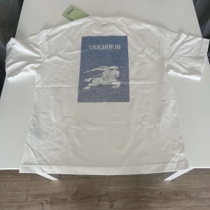 Burberry T-Shirt - Vit Burberry t-shirt i storlek S men oversized. Oanvänd med lapp kvar.