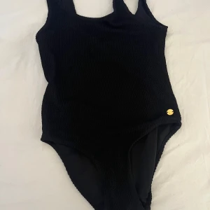 Barn baddräckt  - jätte fin och väl använd men ändå inga defekter. jätte fint mönster på och en liten guld detalj där fram vid ena sidan. 