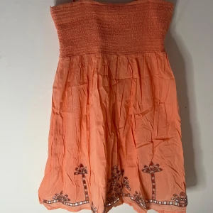  Klänning från Vila - Jätte fin persikofärgad klänning från Vila. Klänningen är i lätt och tunnt material, perfekt för varma dagar.