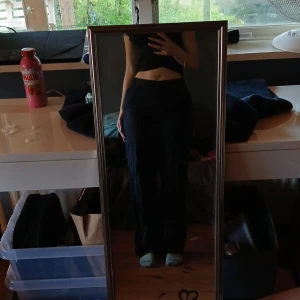 Svarta vida byxor med hög midja - Säljer ett par svarta byxor med hög midja och vida ben. Byxorna har en klassisk look och passar perfekt till en trendig stil. Materialet ser ut att vara mjukt och följsamt, vilket gör dem bekväma att bära hela dagen.