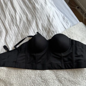 Svart korsett topp - Svart korsett topp från Shein, helt oanvänd. I storlek 38 m. Toppen har ett ”gummi band” längs hela toppen så den sitter på plast. Axelbanden är avtagbara.