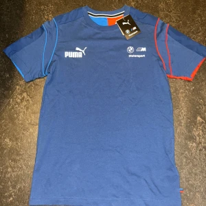 Blå BMW Motorsport t-shirt från Puma stl S - Säljer en blå t-shirt från Puma i samarbete med BMW Motorsport. Perfekt för dig som gillar motorsport och snygg streetstyle. Helt ny 