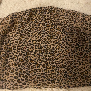 Leopardmönstrad tubtopp - Säljer en snygg tubtopp med leopardmönster i beige, svart och bruna toner. Perfekt för sommaren