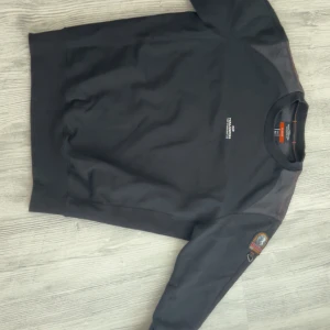 Svart fleece-tröja från Parajumpers - Säljer en svart fleece-tröja från Parajumpers i storlek M. Tröjan har lång ärm, rund hals och ett broderat Parajumpers-märke på ena ärmen. Perfekt för kyliga dagar och har en mjuk insida. Nypris är 2700kr men säljer den för endast 2000kr då den är använd men fortfarande bra skick, Priset går att diskuteras och skriv om ni har frågor!