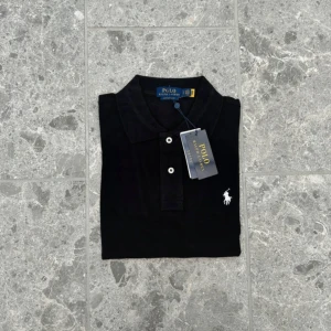 Polo Ralph Lauren piké  - Klassisk svart pikétröja från Polo Ralph Lauren. Tillverkad i bomull och levereras med originalpåse och tag kvar.