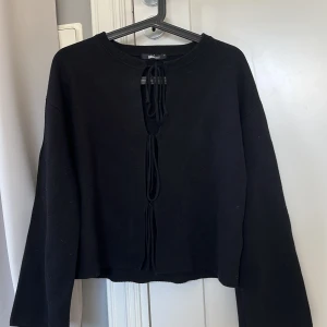 Svart stickad tröja med snörning  - Säljer en svart stickad tröja från Gina Tricot med snörningsdetalj framtill. Knappast använd, pris kan diskuteras🤎