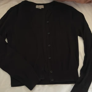 Svart kofta från H&M - Säljer en  svart kofta från H&M i storlek XS. Koftan har långa ärmar och knappar framtill hör av er om ni har frågor!🩷