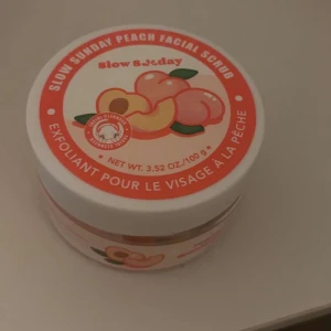 Slow Sunday Peach Facial Scrub - Peach Facial Scrub från Slow & Steady i en söt burk med persikomotiv. Innehåller 100 g exfolierande ansiktsskrubb med en fräsch doft av persika. Perfekt för att ge huden en mjuk och len känsla.
