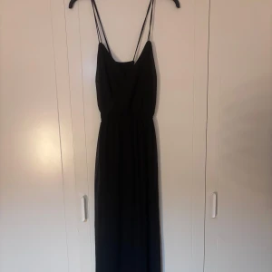 Svart långklänning med smala axelband - Elegant svart långklänning med smala axelband och en stilren design. Klänningen har en enkel look som passar många tillfällen.🌸Från Ginatricot