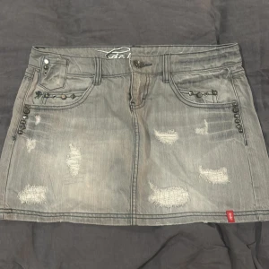 Grå jeanskjol från Esprit - Snygg grå jeanskjol från Esprit med slitna detaljer och nitar på fickorna. Dom är lågmidjade och passar perfekt till sommaren. Skriv gärna om ni har frågor🖤pris kan även diskuteras vid snabbt köp