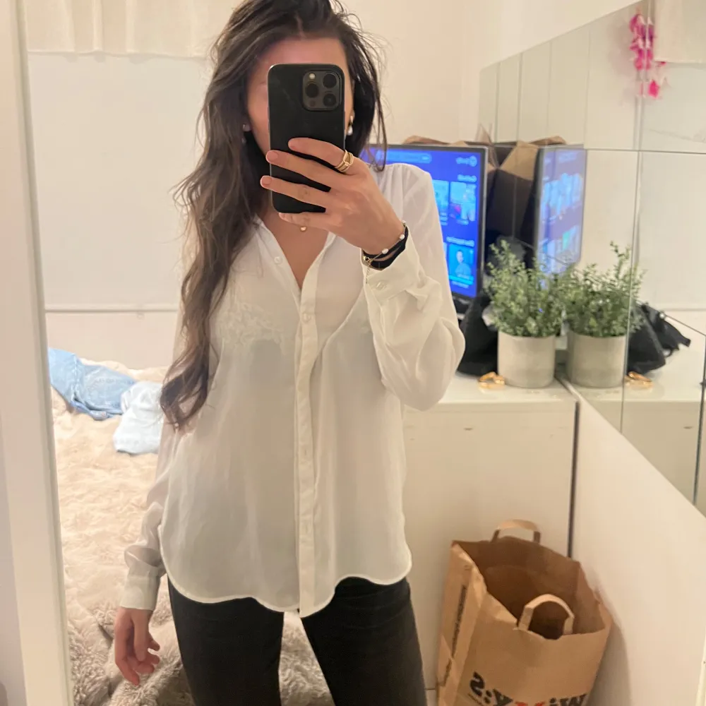 Snygg och stilren vit blus med knappar framtill. Perfekt för en chic och avslappnad look. Blusen har långa ärmar och en klassisk krage.. Paidat.