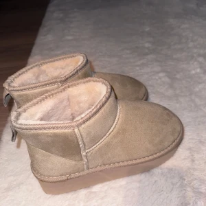 Beige boots med foder - Mysiga beige boots från Krush med mjukt foder. Perfekta för kalla dagar, dessa boots har en rund tå och är tillverkade i mocka. De är designade för att hålla fötterna varma och bekväma. Köpta på Boohoo.