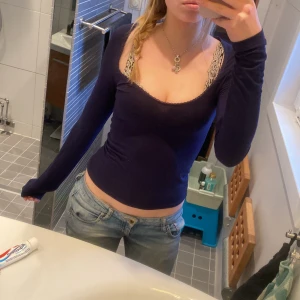 Marinblå tröja från Nelly  - Säljer en mörkblå topp från Nelly med spetsdetaljer vid halsringningen. Toppen har långa ärmar och en tight passform, perfekt för en stilren look. Passar bra till både jeans och kjol. 💙