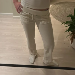 Vita mjukisbyxor från Juicy Couture - Säljer ett par vita mjukisbyxor från Juicy Couture i storlek XS. Byxorna har en bekväm passform med snörning i midjan och fickor fram. Perfekta för en avslappnad stil.